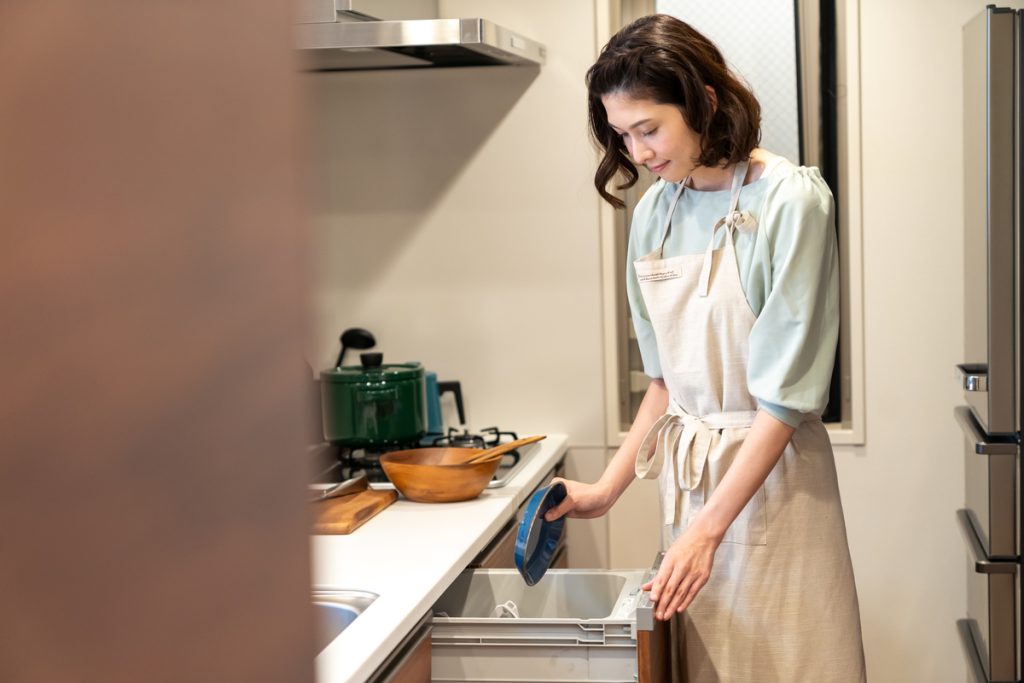 ビルトイン食洗機から小皿を取り出す女性