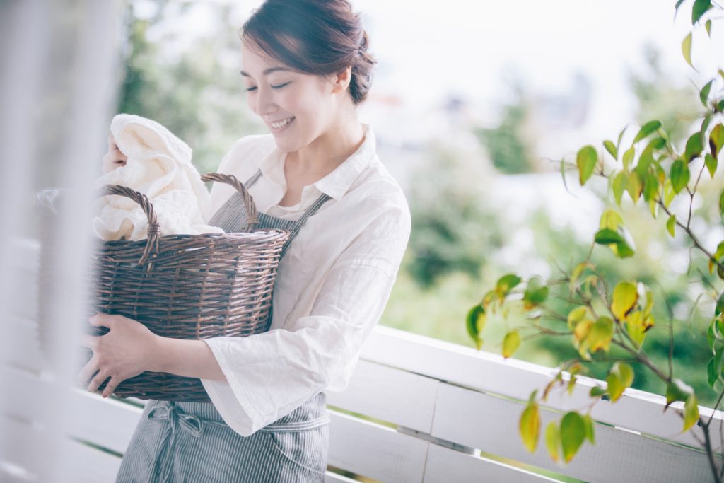 洗濯カゴを持って微笑む女性