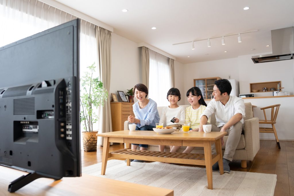 楽しげにテレビ視聴する家族