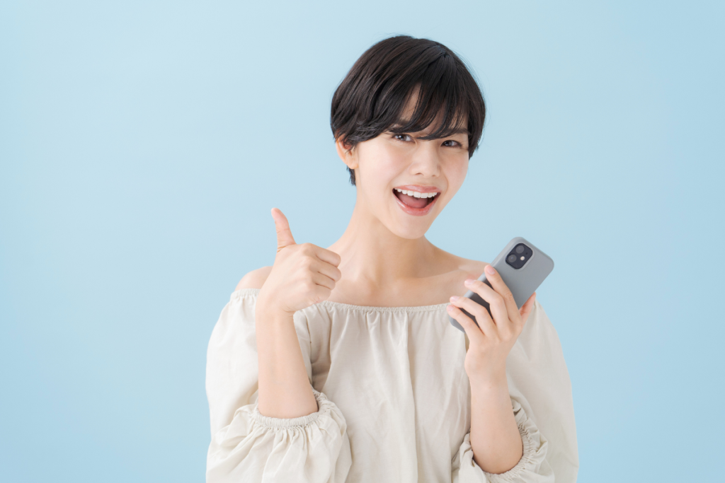 スマホを持って微笑む女性