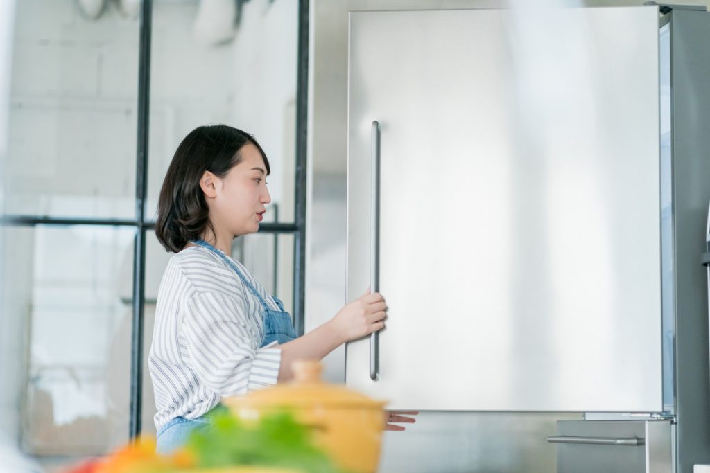 冷蔵庫を開ける女性