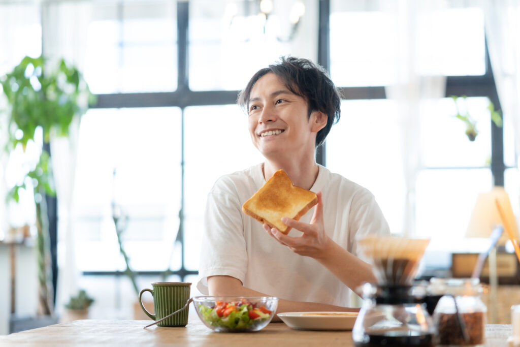 朝食にトーストを食べる男性