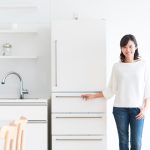 冷蔵庫の横に立つ女性