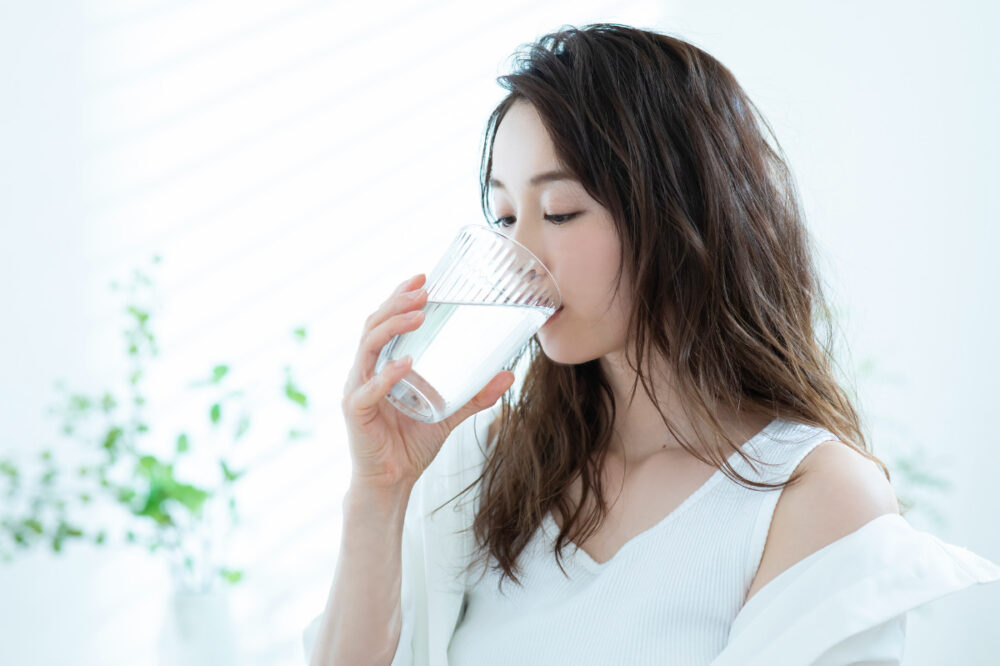 グラスに入った水を飲む女性