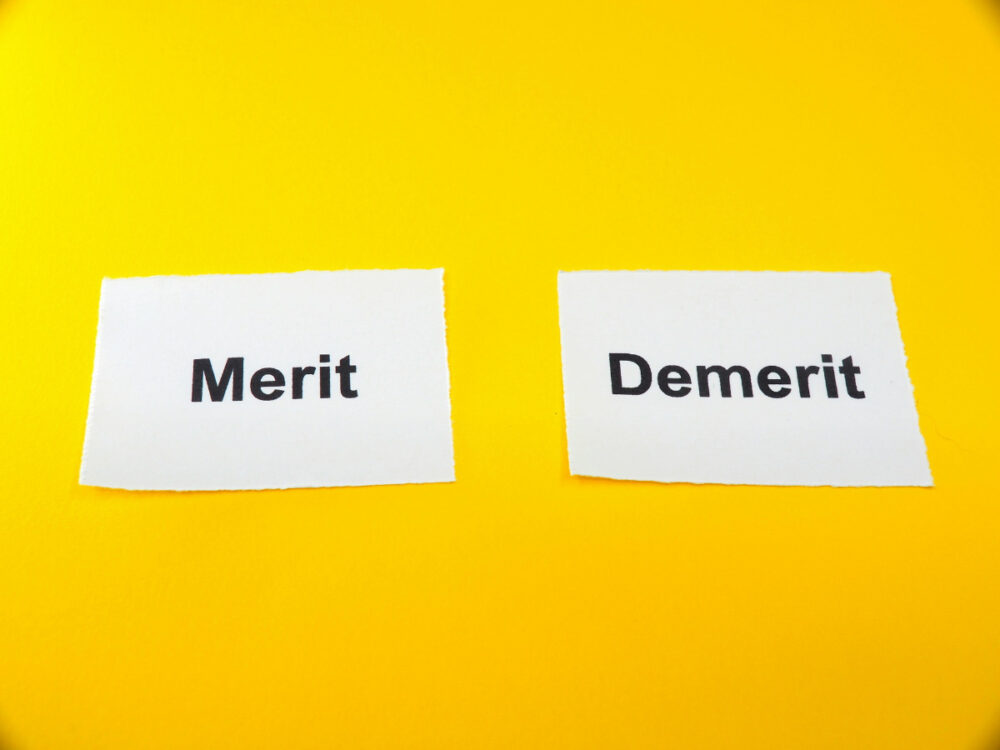 2枚の紙に書かれたMerit、Demeritの文字